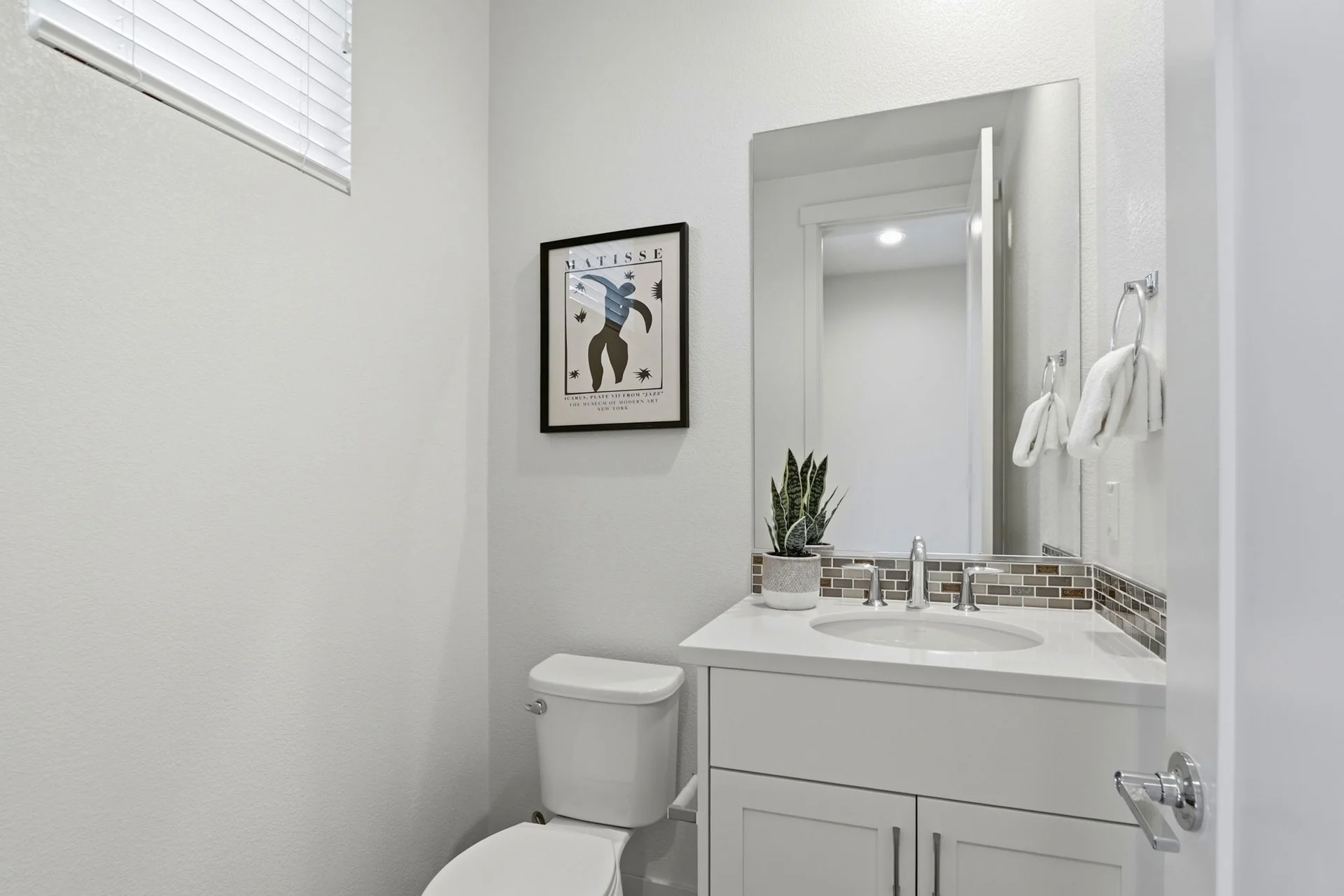 Powder room with framed art and tiled backsplash