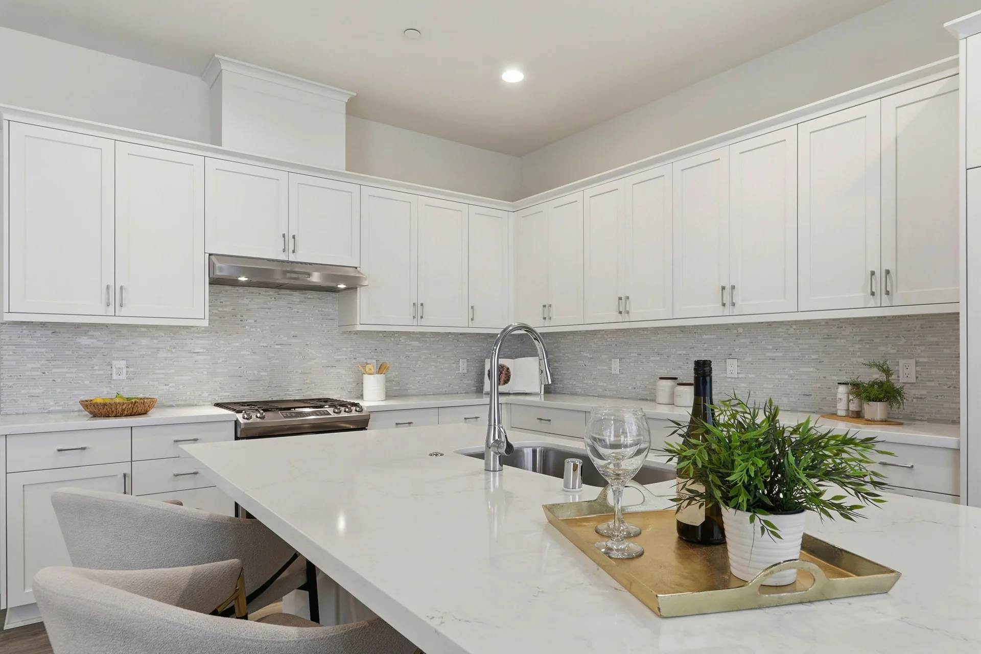 White kitchen with island, sink, and tile backsplash