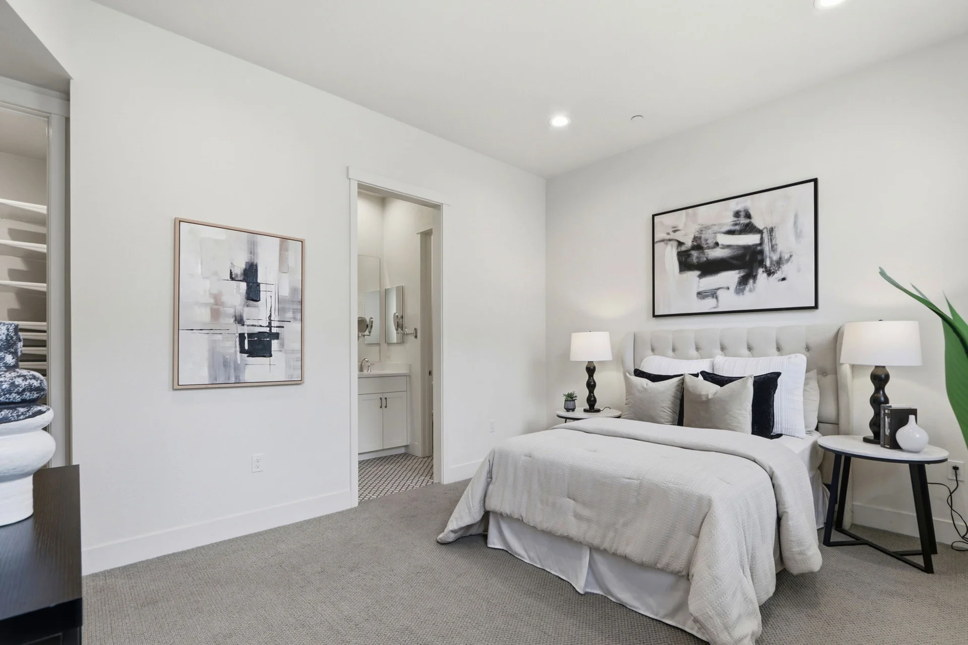 Primary bedroom with tufted headboard, en-suite and closet beyond