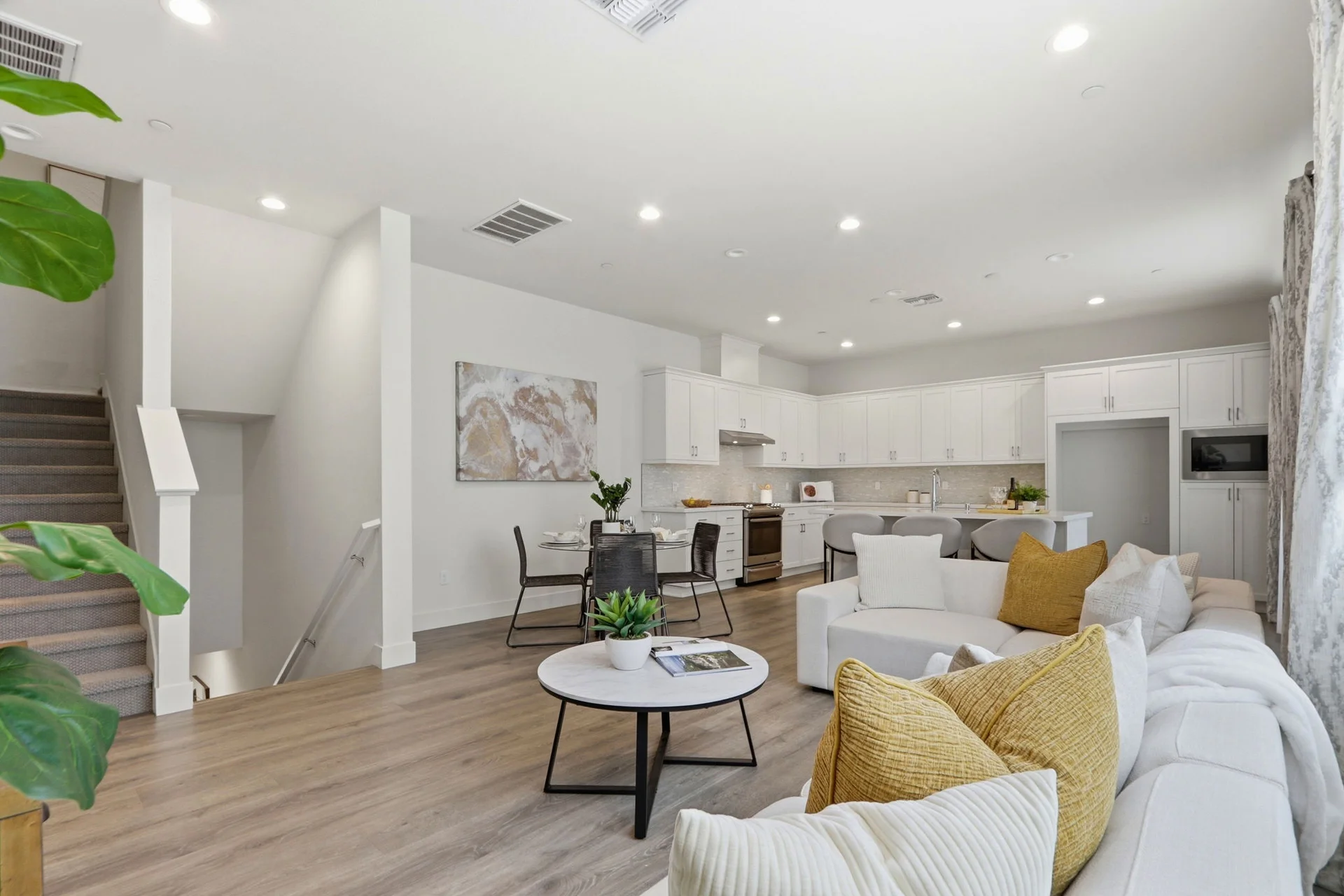 Open living area with sectional, dining table, and kitchen beyond