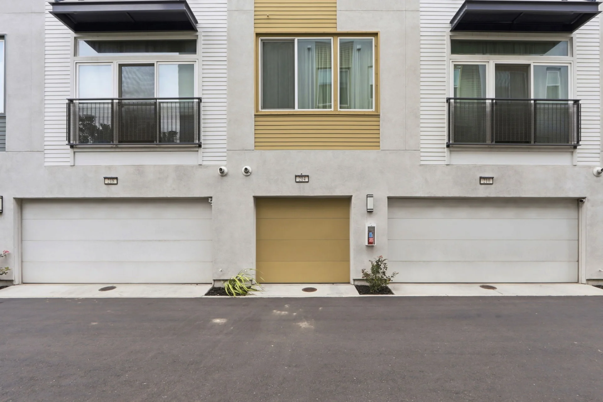 Rear elevation with 214's gold garage door centered between its neighbors