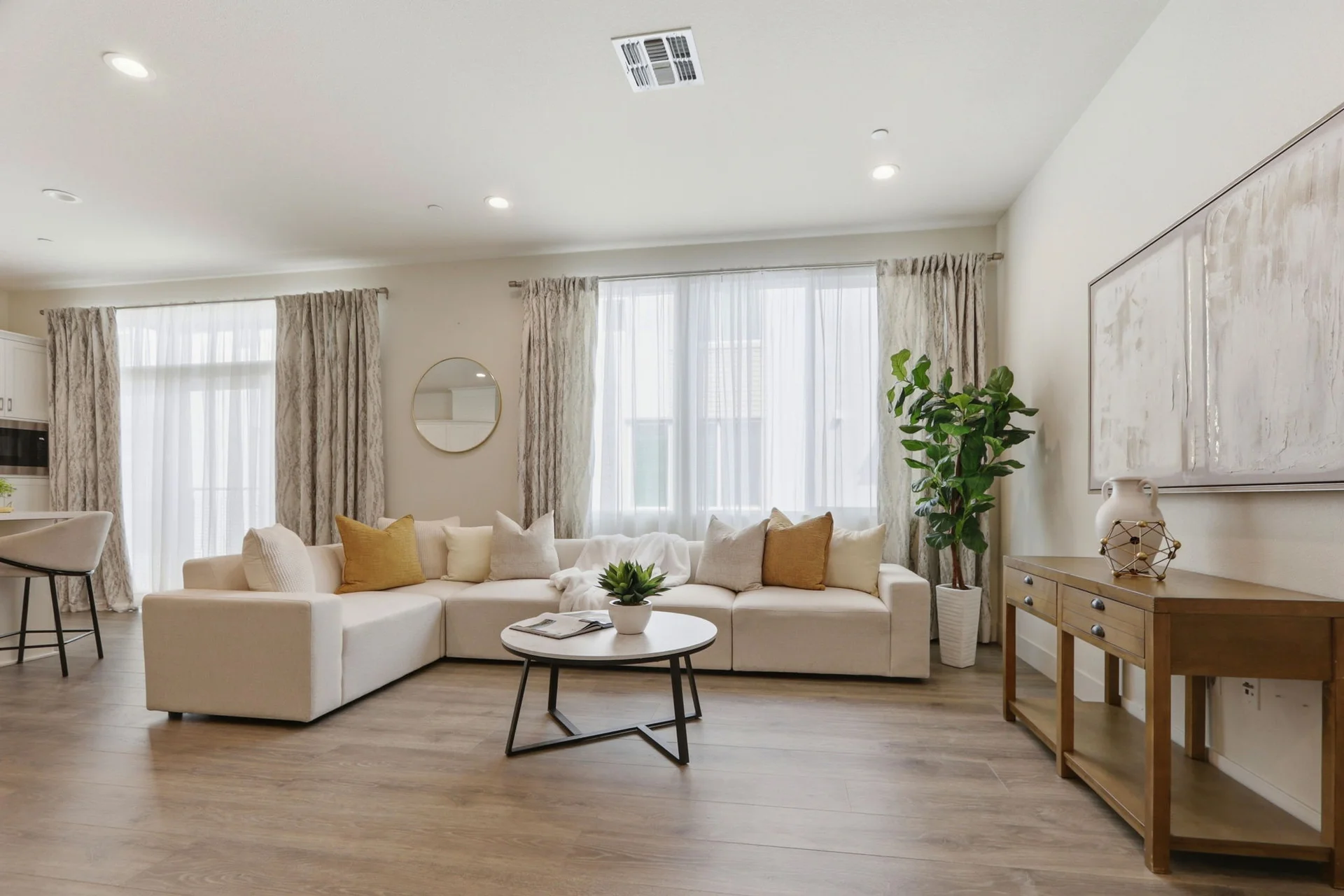 Living room in soft window light — cream sectional and oak console