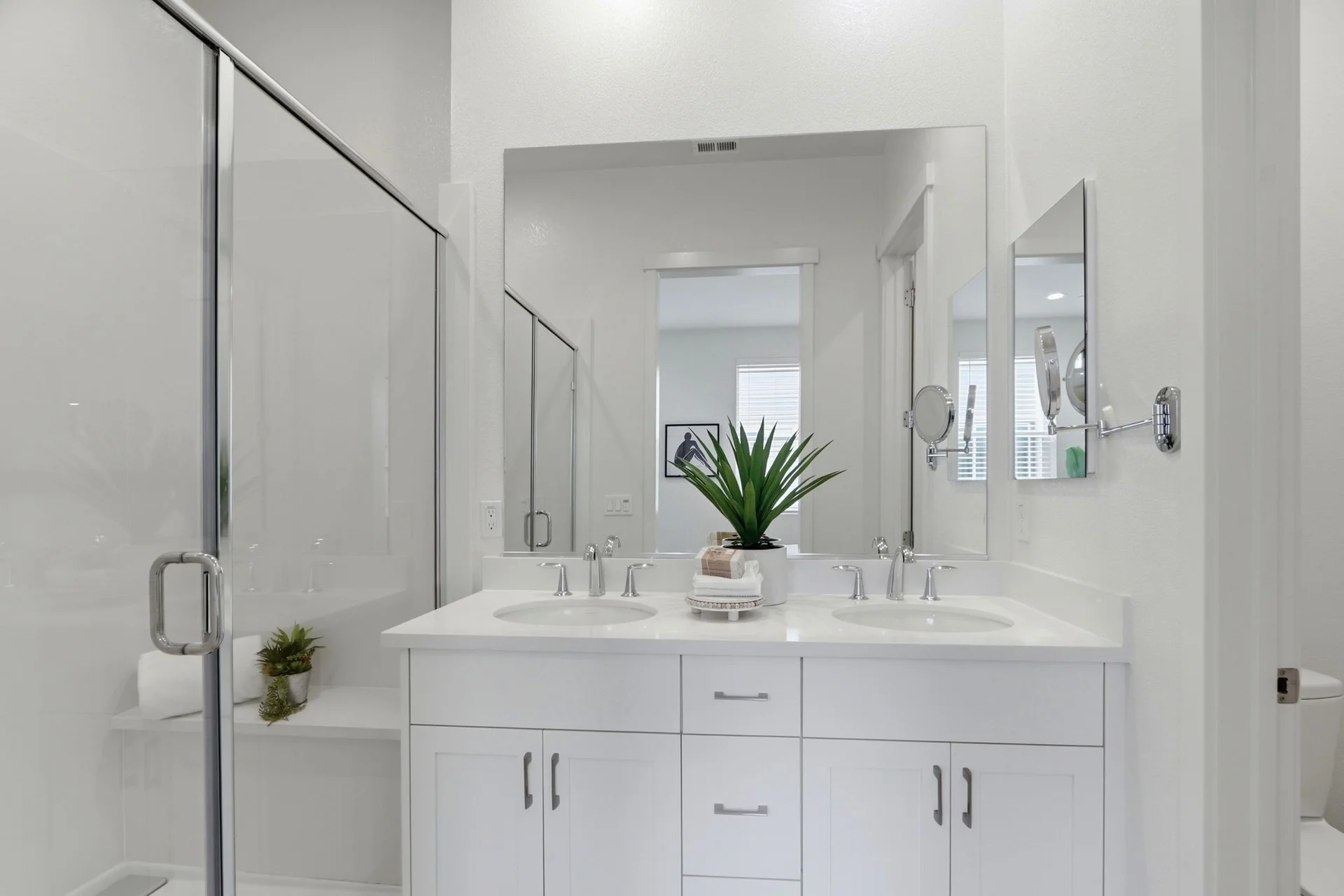 Primary bathroom with double vanity and glass shower